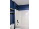 Bathroom shower and tub featuring blue accent wall and minimalist shelving at 186 Majesty Dr, Rockmart, GA 30153