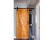 Rustic style bedroom with rolling barn door entry and ceiling fan at 186 Majesty Dr, Rockmart, GA 30153