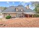 Backyard exterior view with covered patio and brick walkway in wooded setting at 2407 Honey Ct, Mcdonough, GA 30252