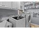 Bright laundry room with white cabinets, shelving, utility sink, and modern Samsung washer and dryer at 2407 Honey Ct, Mcdonough, GA 30252