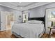 Spacious primary bedroom with hardwood floors, tray ceiling, and an adjacent bathroom suite at 2407 Honey Ct, Mcdonough, GA 30252