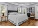 Bright main bedroom with hardwood floors, two windows, and neutral decor at 2407 Honey Ct, Mcdonough, GA 30252