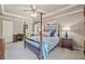 Spacious main bedroom with four-poster bed, tray ceiling, soft carpet, and large windows offering ample natural light at 2885 Arborwoods Dr, Alpharetta, GA 30022