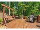 Inviting deck with swing and grill, offering a peaceful retreat surrounded by mature trees at 2885 Arborwoods Dr, Alpharetta, GA 30022