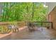Relaxing wood deck with outdoor seating and pergola, surrounded by lush greenery and mature trees at 2885 Arborwoods Dr, Alpharetta, GA 30022