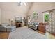 Bright living room with vaulted ceiling, a large arched window, light gray walls, hardwood floors, and a cozy seating area at 2885 Arborwoods Dr, Alpharetta, GA 30022