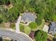 Stunning aerial view of a home with lush landscaping, a circular driveway, and mature trees on a spacious lot at 330 Plantation Way, Roswell, GA 30075
