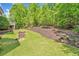 Landscaped backyard featuring lush greenery and patio with stone steps at 330 Plantation Way, Roswell, GA 30075
