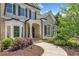 Inviting front entrance features brick accents, a covered porch, and manicured landscaping creating a warm welcome at 330 Plantation Way, Roswell, GA 30075
