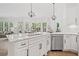 Kitchen with stainless steel appliances, stone countertops, and large windows overlooking the backyard at 330 Plantation Way, Roswell, GA 30075