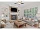 Cozy living room features a stone fireplace, built-in shelving, plantation shutters, and lots of natural light at 330 Plantation Way, Roswell, GA 30075