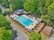 Aerial view of community pool featuring lounge chairs, umbrellas, and mature trees at 3585 Legacy Trce, Alpharetta, GA 30022