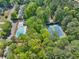 Aerial view showcases community pool and tennis courts surrounded by lush greenery and mature trees at 3585 Legacy Trce, Alpharetta, GA 30022