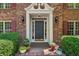 Inviting front entry featuring a decorative door, brick walkway, and manicured greenery at 3585 Legacy Trce, Alpharetta, GA 30022