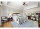 Bright main bedroom with tray ceilings, ceiling fan, and ensuite bathroom at 3585 Legacy Trce, Alpharetta, GA 30022