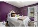 Bedroom with bright purple walls, white accents, and a comfortable bed with decor at 2022 Ramblewood Ne Ct, Marietta, GA 30062