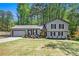 Inviting home featuring a bright yellow front door, lush green lawn, and attached garage at 2022 Ramblewood Ne Ct, Marietta, GA 30062