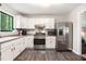 Bright kitchen featuring white cabinets, stainless steel appliances, and a view of the trees at 2022 Ramblewood Ne Ct, Marietta, GA 30062