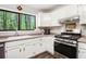 Close up of kitchen with stainless steel oven and hood, gas range, and white cabinets at 2022 Ramblewood Ne Ct, Marietta, GA 30062