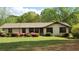 Charming single-story home with green lawn and colorful blooming bushes at 4909 Woodhurst Way, Stone Mountain, GA 30088