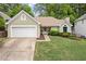 Charming home featuring a well-manicured lawn, complemented by a 2-car garage and a delightful pink front door at 1970 Glen Eves Dr, Roswell, GA 30076