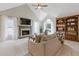 Bright living room with a fireplace, built-in bookcase, and a large window, creating a cozy and inviting atmosphere at 1970 Glen Eves Dr, Roswell, GA 30076