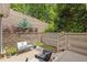 Outdoor patio featuring a bench and chairs with a retaining wall and lush greenery backdrop at 1970 Glen Eves Dr, Roswell, GA 30076