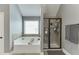 This bathroom features a bathtub, walk-in shower with glass door, and a large window for natural light at 3097 Trinity Grove Dr, Dacula, GA 30019
