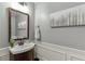 Elegant half bath featuring modern fixtures, stylish mirror, and wainscoting at 3097 Trinity Grove Dr, Dacula, GA 30019