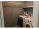 A modern laundry area featuring a front-load washer and dryer with overhead shelving at 3097 Trinity Grove Dr, Dacula, GA 30019