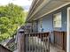 Apartment balcony with wooden railing and chairs overlooking green trees and building exterior at 562 Formwalt Sw St # 4, Atlanta, GA 30312
