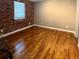 Bedroom with hardwood floors and a brick accent wall creating an inviting atmosphere at 562 Formwalt Sw St # 4, Atlanta, GA 30312