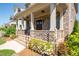 Charming front porch with brick accents, columns, and a welcoming entrance with beautiful landscaping at 168 Brighton Blvd, Woodstock, GA 30188