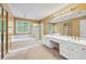 Spacious primary bath featuring dual sinks, soaking tub, separate shower, and large mirror with vanity lighting at 10044 Point View Dr, Jonesboro, GA 30238