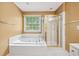 Bright bathroom features a large soaking tub with tile surround and glass enclosed shower at 10044 Point View Dr, Jonesboro, GA 30238