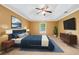 Cozy bedroom features a tray ceiling, ceiling fan, and neutral décor with a king bed and ensuite at 10044 Point View Dr, Jonesboro, GA 30238