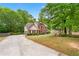 Traditional brick home with a well-manicured lawn, long driveway, and mature trees at 10044 Point View Dr, Jonesboro, GA 30238