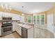 Open kitchen with stainless steel appliances, pink countertops, and a chandelier lighting at 10044 Point View Dr, Jonesboro, GA 30238