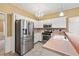 Renovated kitchen with stainless steel appliances, pink countertops, and chandelier lighting at 10044 Point View Dr, Jonesboro, GA 30238