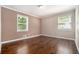 Simple bedroom features wood floors, two windows for natural light, neutral paint, and molding at 1085 Azalea Ne Cir, Marietta, GA 30062