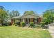 Quaint brick home featuring a lush green lawn, mature shrubbery, and a welcoming front entrance at 1085 Azalea Ne Cir, Marietta, GA 30062