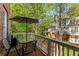 Outdoor balcony with patio table and chairs surrounded by lush greenery at 1144 Bellewood Sq, Dunwoody, GA 30338
