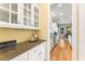 Charming kitchen with granite counters, wooden floors, and custom white cabinetry, adjacent dining area at 1144 Bellewood Sq, Dunwoody, GA 30338