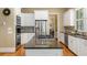 Bright kitchen featuring granite counters, an island cooktop, stainless appliances, and white cabinets at 1144 Bellewood Sq, Dunwoody, GA 30338