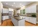Bright kitchen featuring granite counters, an island cooktop, stainless appliances, and white cabinets at 1144 Bellewood Sq, Dunwoody, GA 30338