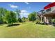 Expansive backyard with lush green grass, mature trees, and a deck perfect for outdoor entertaining at 6090 Pennant Ln, Suwanee, GA 30024
