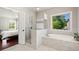 Bright and airy bathroom featuring a soaking tub and glass shower at 6090 Pennant Ln, Suwanee, GA 30024