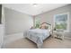 Bedroom featuring two windows with blinds, a queen-size bed and a side table at 6090 Pennant Ln, Suwanee, GA 30024