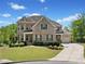 Beautiful two-story brick home with a well-manicured lawn and attached garage on a sunny day at 6090 Pennant Ln, Suwanee, GA 30024