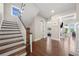 Bright foyer with hardwood floors and staircase leading to the upper level, with views into living spaces at 6090 Pennant Ln, Suwanee, GA 30024